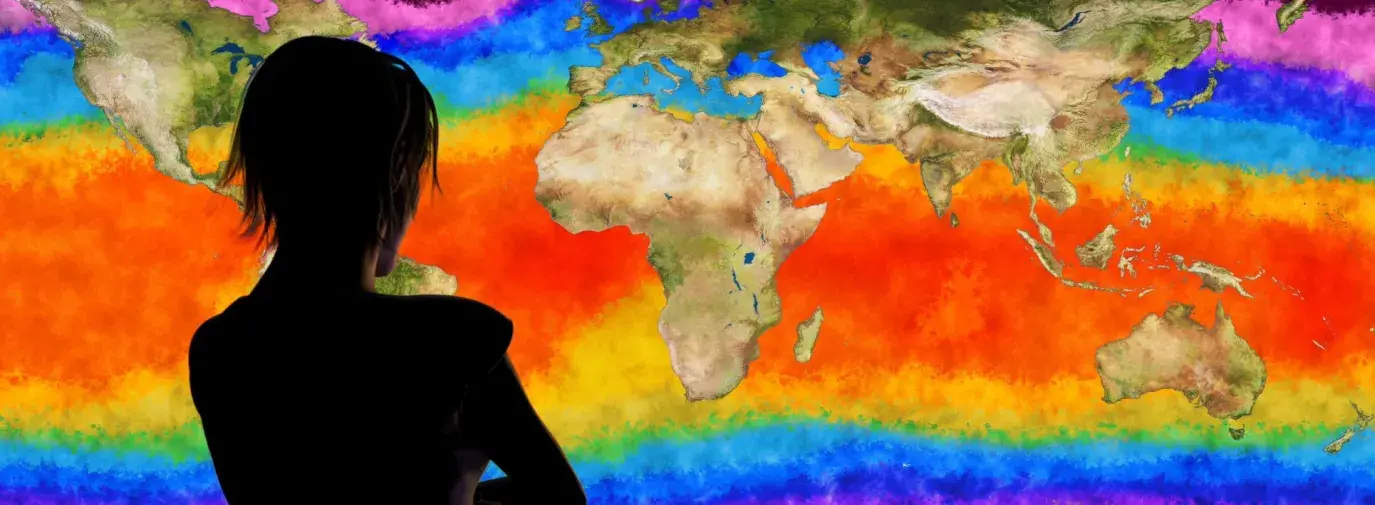 silhouette of a person looking at a map where the ocean is a rainbow